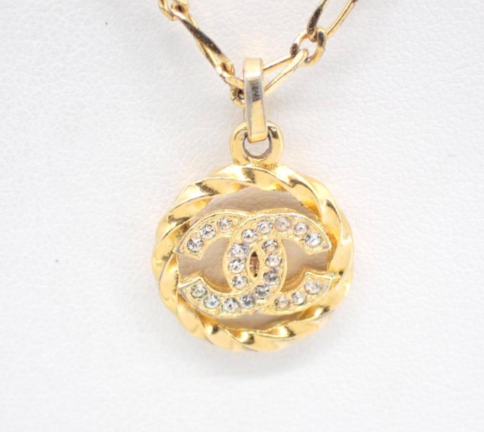 1982 Vintage Chanel Gold-tone chain with round CC medallion pendant featuring crystal accents